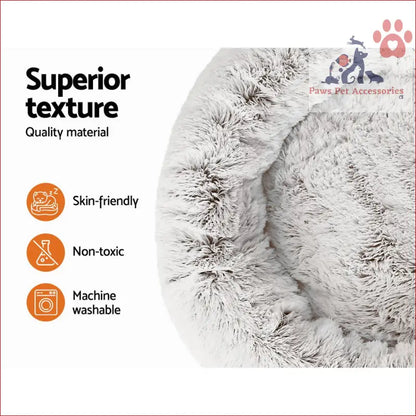 Plush gray circular cushion on a large calming soft pet bed dog in white and brown