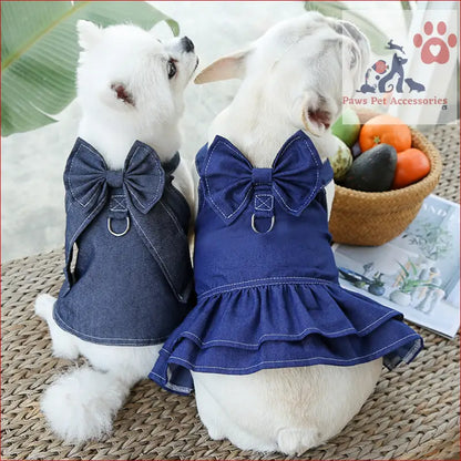 Two white dogs in matching denim harness dress set with bow ties and leash ring